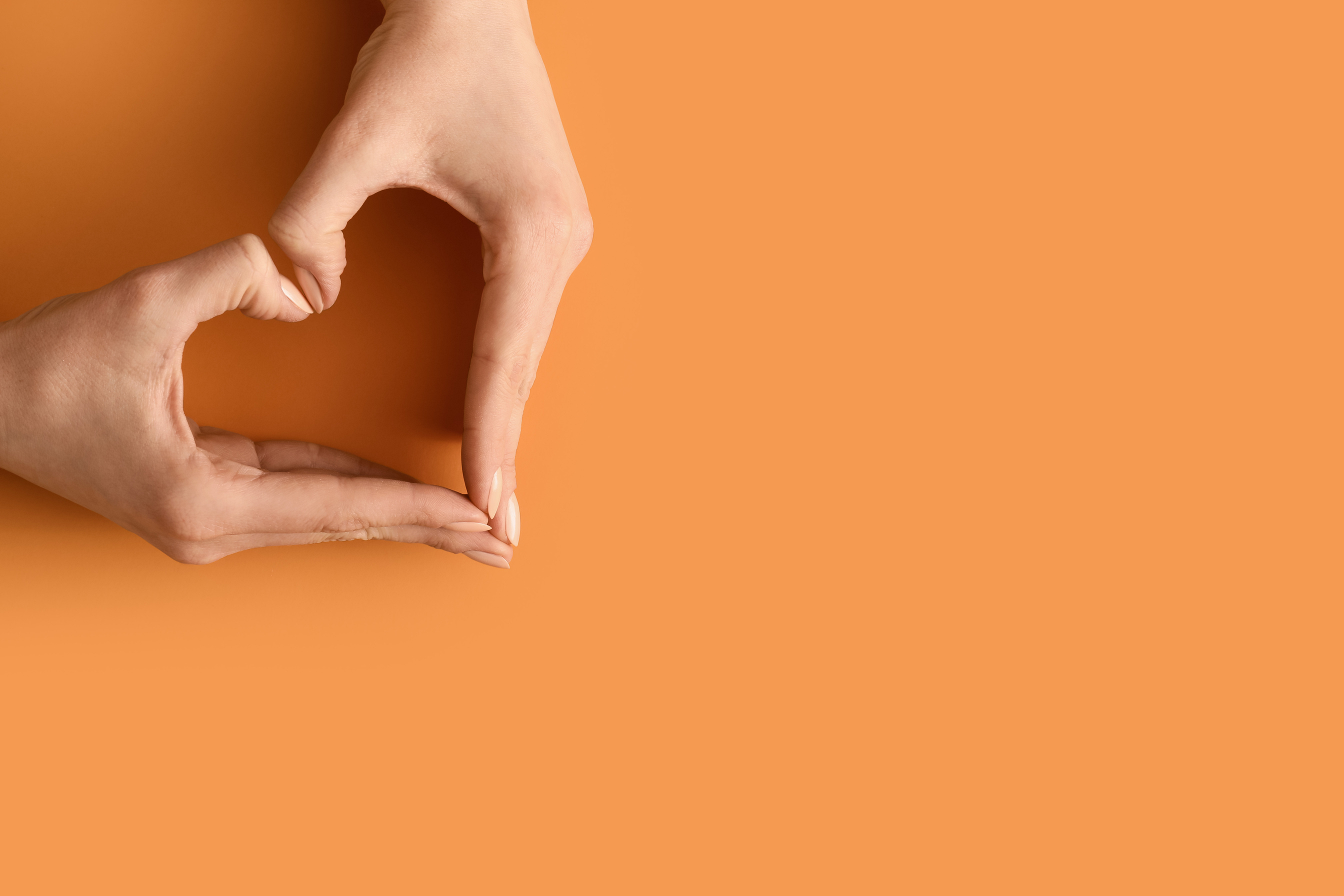 Hands Making Heart on Color Background